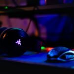 Image of an headphone and mouse meant for gaming. Dark image with colors.